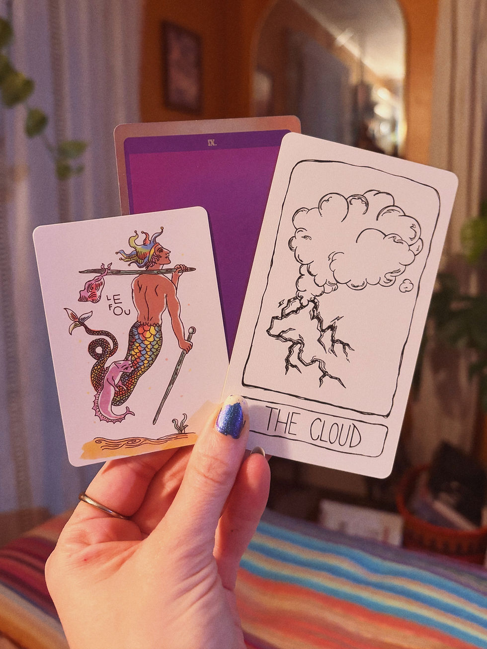 A hand holding up 3 divination cards: The Fool, Purple, and The Cloud