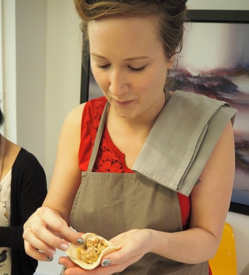 Person shaping a dumpling by hand during a dim sum cooking class in Hong Kong.
