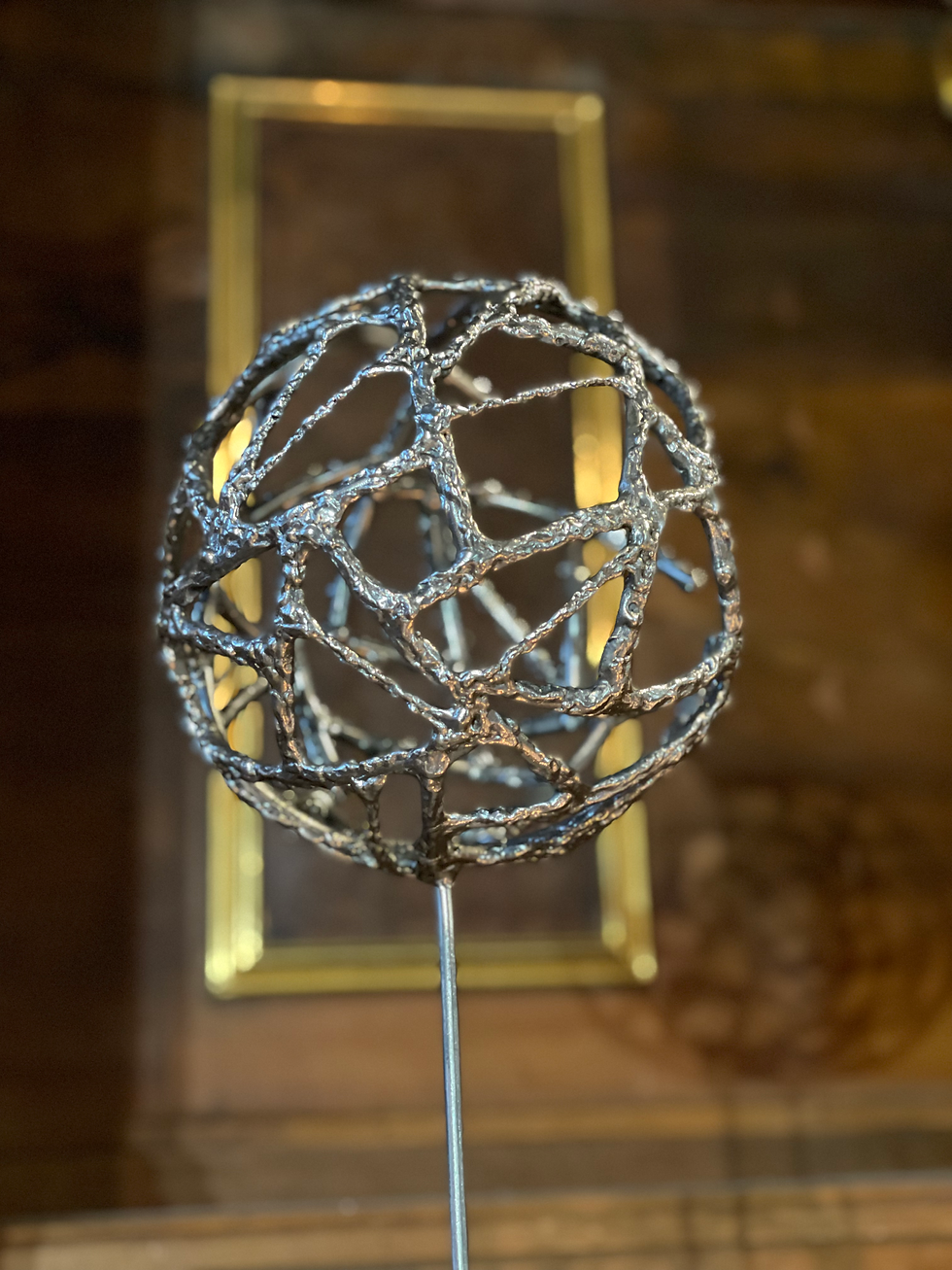 Miniaturbild: Stahlskulptur mit Schattenwurf – organische Kugelstruktur auf Betonbasis