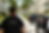 Fotografia em plano médio de agentes da Polícia Civil de Minas Gerais, de costas, vestindo uniformes pretos com a inscrição "POLÍCIA CIVIL" em destaque. Eles estão em uma área comum de um condomínio residencial com prédios claros, palmeiras e gramados ao fundo. Um dos agentes observa o ambiente enquanto outros dois ao fundo parecem registrar informações.