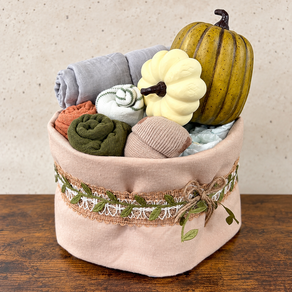 Rustic fall baby diaper cake with rolled baby essentials, pumpkins, and leafy lace trim.