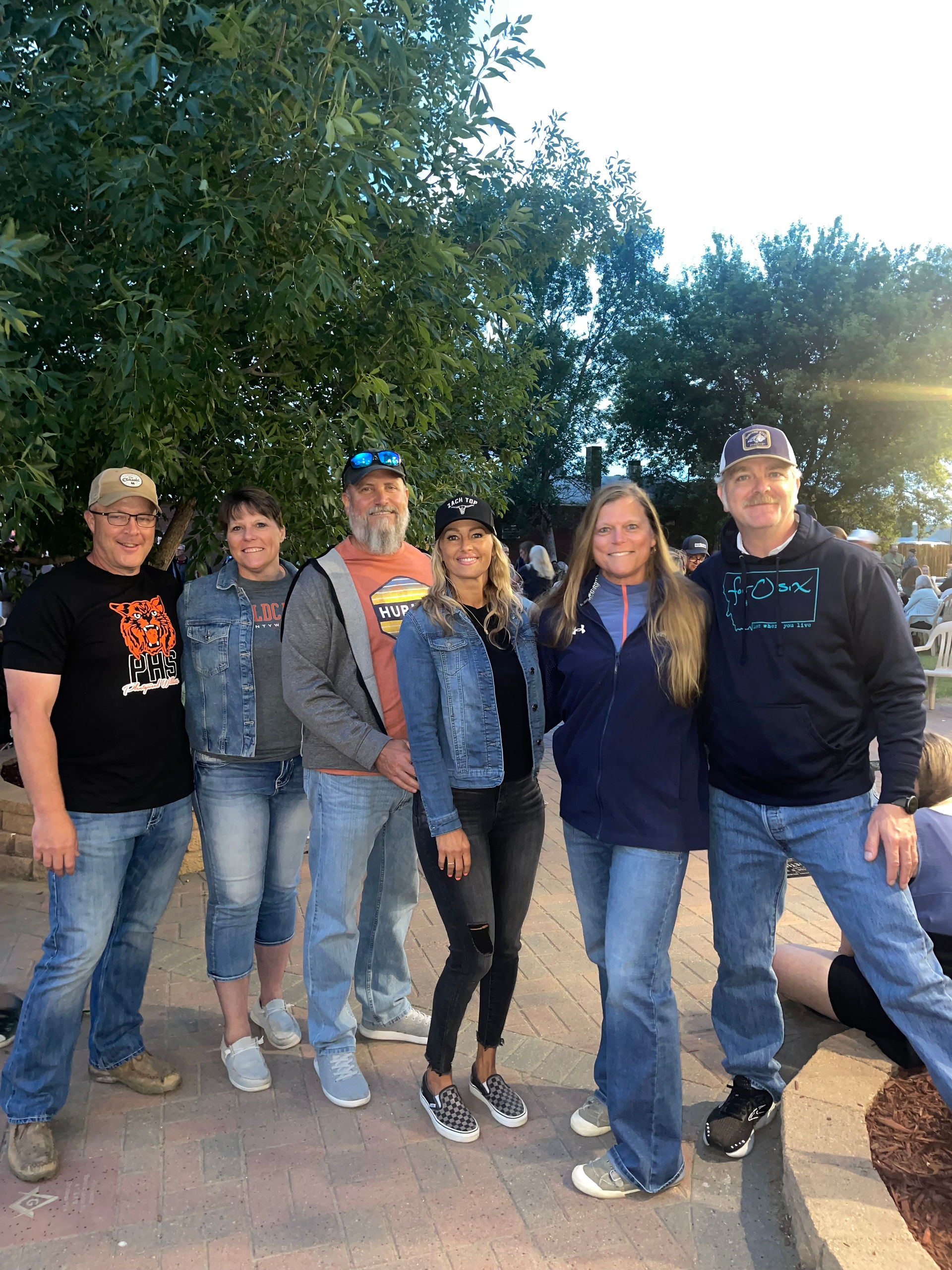 Group of people smiling for photo, wearing various denim jackets. All-School Reunion.