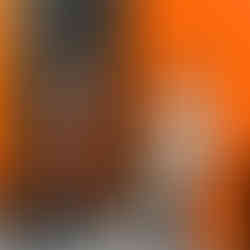 Two young children wearing orange and white near black and orange walls.