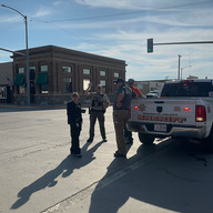 Group of people standing by truck on intersection on a sunny day