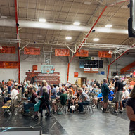 Large group of people inside a gymnasium, All-School Reunion, attending an event.
