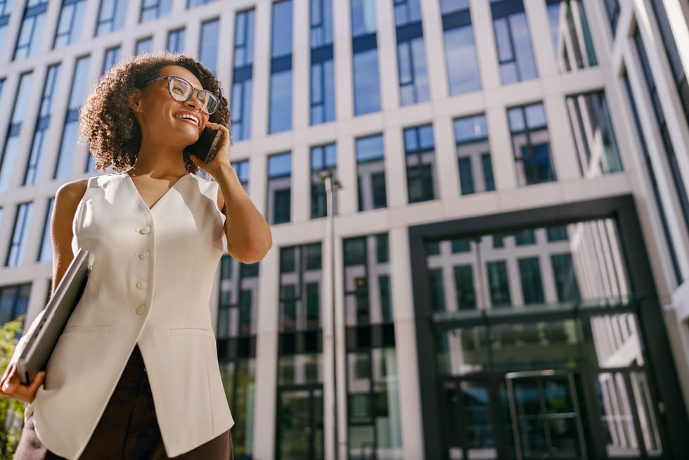 A woman on her mpbile standing outside a building.