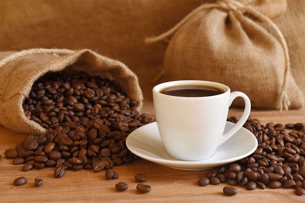 Coffee beans spilling out of a bag and a coffee cup