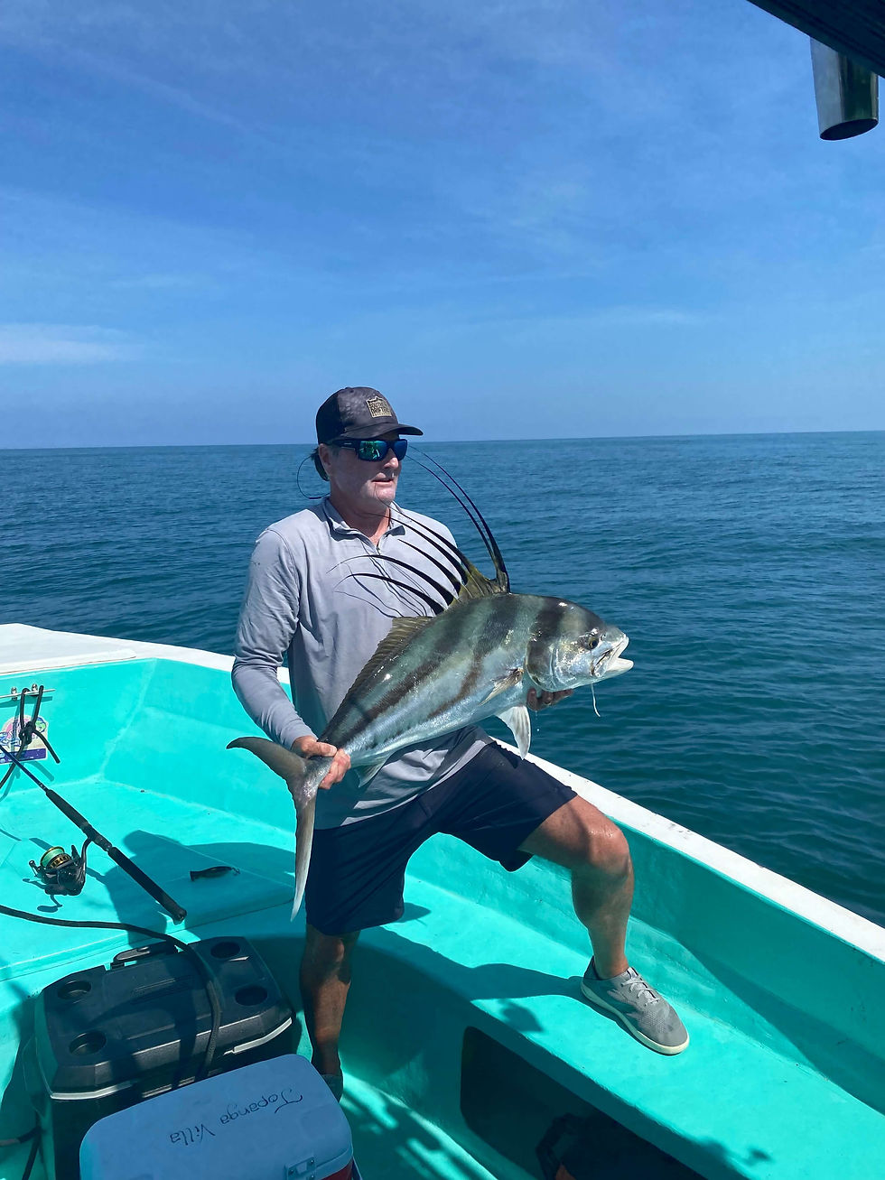 Man holding a Roosterfish on a boat