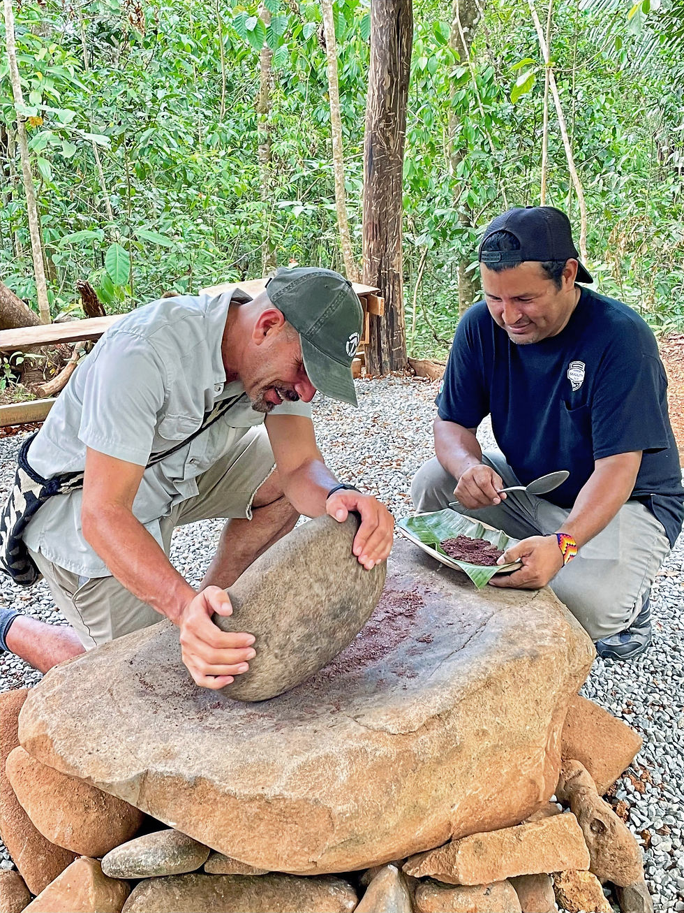 Two men crushing cacao beans making chocolate