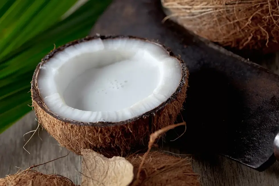A coconut split open showing the white meat and milk