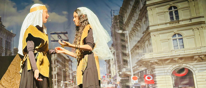 שתי נשים בלבוש עתיק משחקות תיאטרון ברחוב עירוני