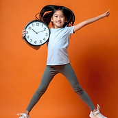 Firefly chinees meisje van 7 jaar in sportkleding maakt danssprong met klok onder haar arm