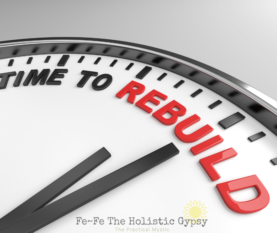 Close-up of a clock face with "Time to Rebuild" in black and red text. Gray background, motivational theme. Text: Fe~Fe The Holistic Gypsy.