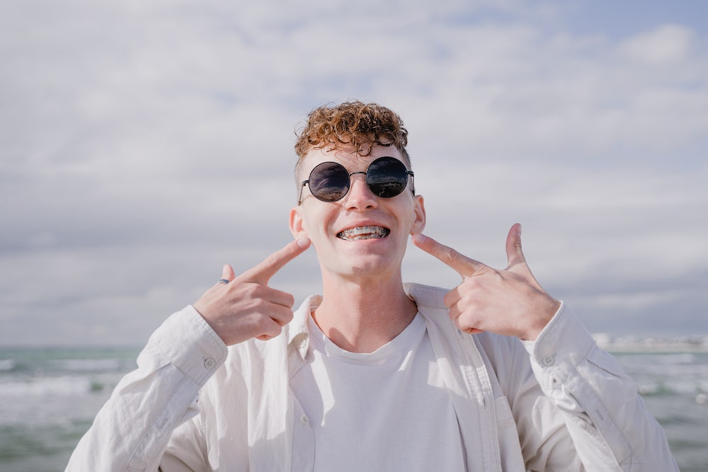 Young male smiling showing off his braces