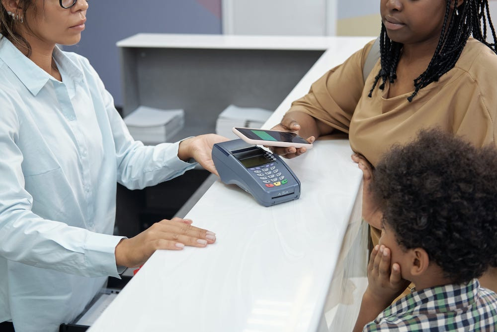 Mom and son paying for dental services