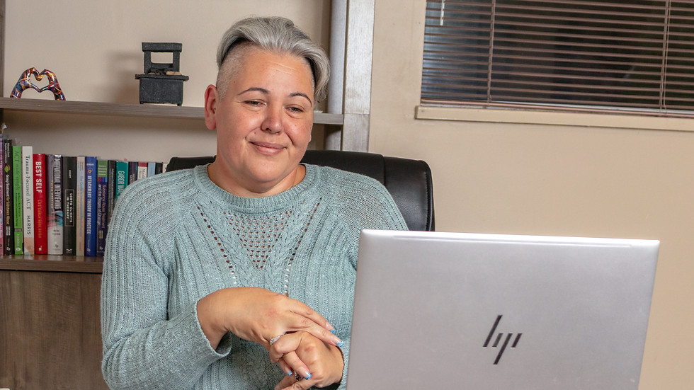 Affirming therapist smiling at laptop