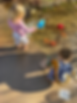 Preschoolers using scoops, shovels, muffin tins and magnifying glasses to play in a creek during a Nature Preschool Class.