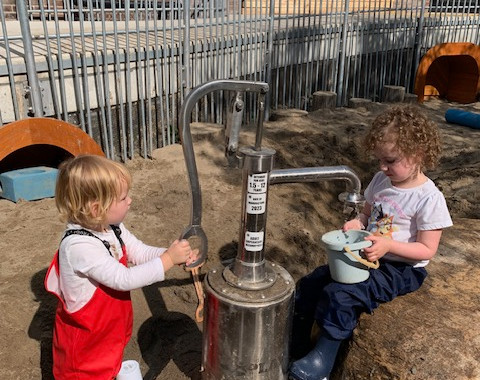 children playing with water pump