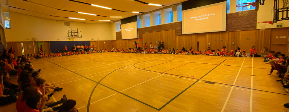 school children and staff gathering in the gym for NDTR and Orange Shirt Day
