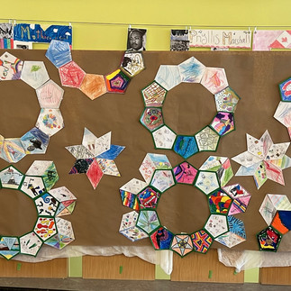 students were provided with paper polygon tiles to build decagrams and stars, mimicking shapes and designs commonly found inside and outside of mosques, intricate designs on Qurans, textiles, and more. They were invited to design a pattern or draw what they felt represented them on the tiles, and the result was a beautiful, celebratory work of collective art!