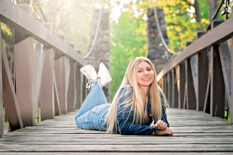 female-senior-posing-on-wooden-bridge.jpg