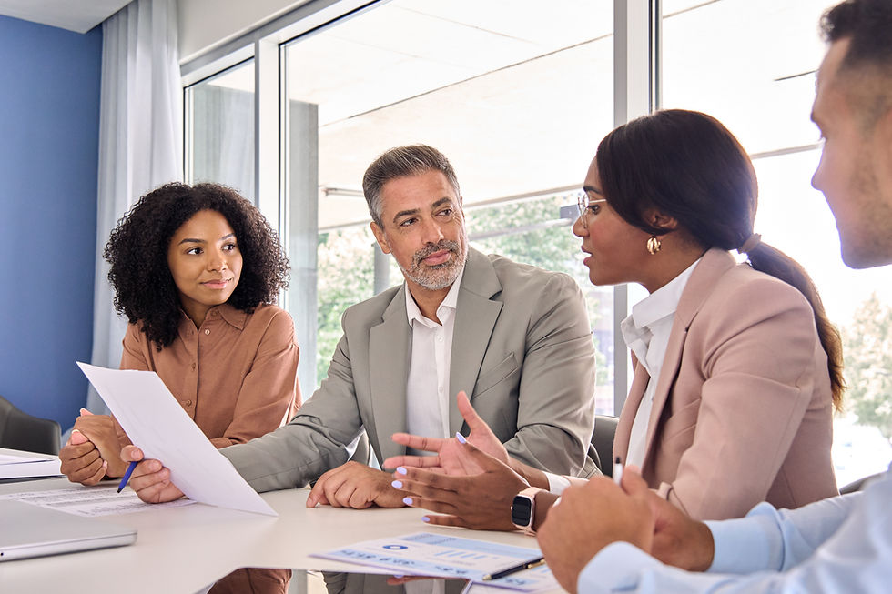 Group of business people in a meeting, discussing documents and ideas.