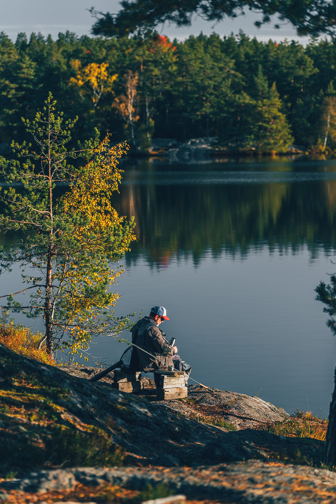 Kaffepaus med macka i solen vid en sjö