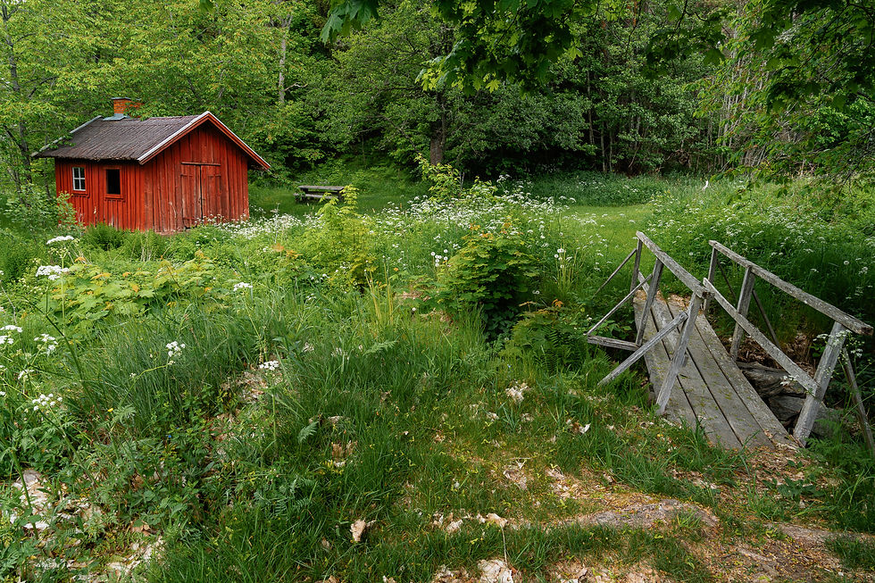 Ett gammalt rött hus med en bro
