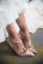 A bride’s leg adorned with a stunning, intricate henna design, elegantly posed against the backdrop of her wedding dress, wit