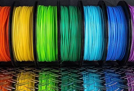 colorful bright row of spool 3d printer pla abs filament plastic material on dark black me