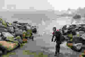A scuba diver exiting a rocky ramp