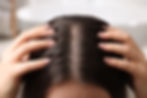 Woman examining her hair and scalp on blurred background, closeup.jpg