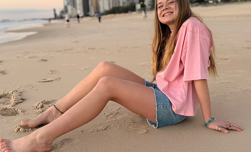 Woman wearing the Wyld Revolution Co Vintage Rose Rebel oversized western graphic tee on an Australian beach.