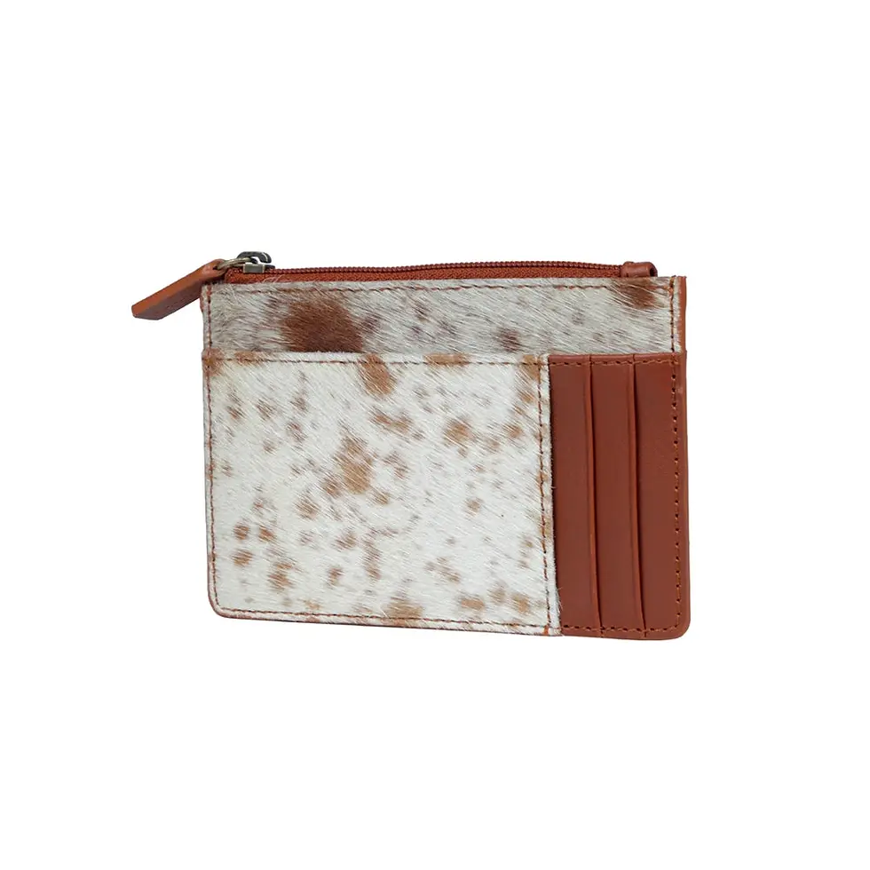 Front view of the Dust Trail hair on hide card holder featuring genuine cowhide, leather trim, zip compartment and card slots