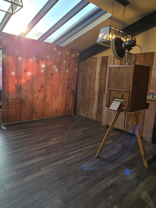 Fells Fun Booth's Vintage Photo Booth set up at Foxtail Barn wedding venue with a rustic wooden backdrop, professional lighting and spacious guest area