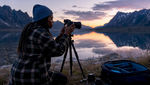Photographer setting up camera in forest at dawn
