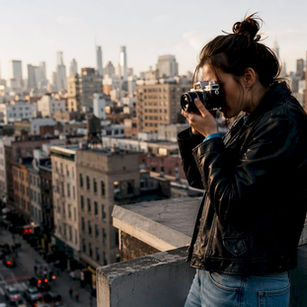 Female street photographer adjusting camera outdoors