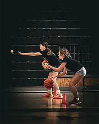 Two young girls practicing ball-handling drills at a Texas Mayhem youth basketball camp in Keller, TX