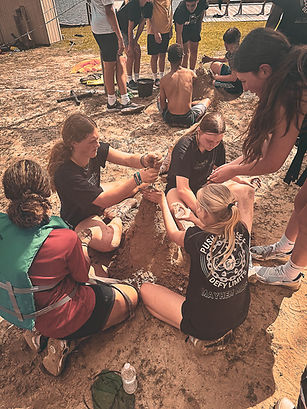 Texas Mayhem girls team participating in sandcastle-building challenge as part of retreat bonding