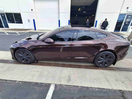 Master technician at Auto Style PPF in Bensenville performing a seamless full front clear bra installation with custom tucked edges on a brand-new Tesla Model Y to protect its soft factory paint from highway rock chips.