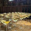 chilled champagne inside coupe glasses on top of a bar, in front of a bar sign