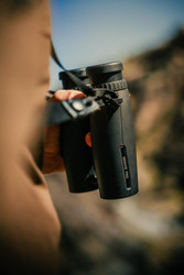 Huntsman And The Butcher hält das Leica Geovid Pro Fernglas im Khomas Hochland in Namibia