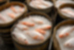 Fish preserved in salt and rice inside a wooden barrel during the narezushi fermentation process, an ancient method of sushi preservation.