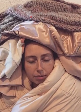 models face under a pile of clothing