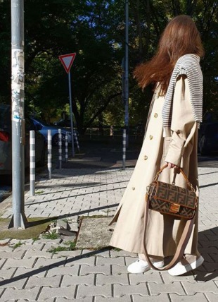 Stylist fashion and style blogger walking with her hair and clothes blowing in the wind
