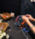 Hands tying colorful ropes at climbing DIY workshops.