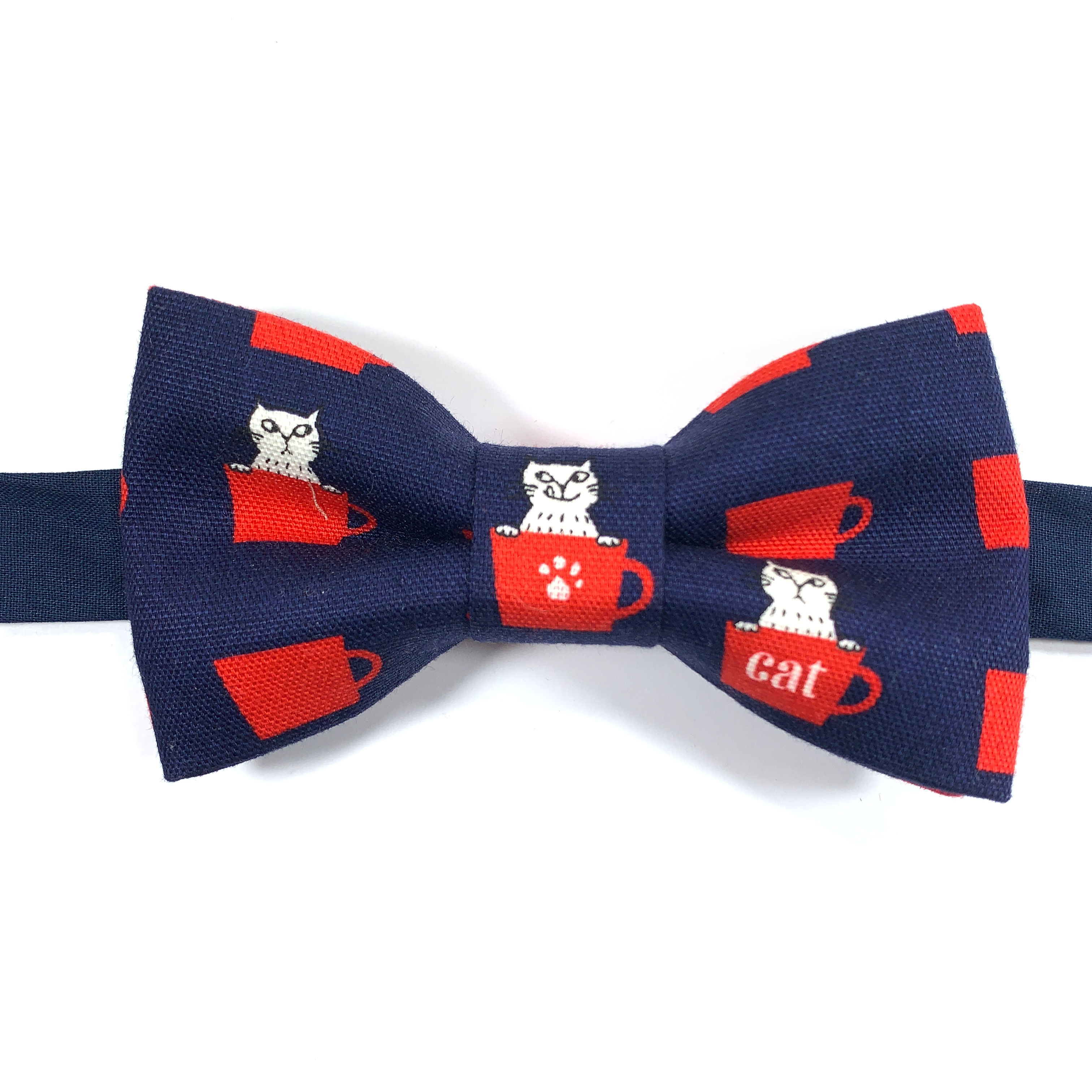 Noeud papillon bleu marine  avec motifs de chats blanc dans une tasse rouge