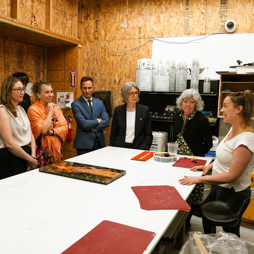 Une femme explique l'artisanat de l'époxy à un groupe de personnes dans une pièce