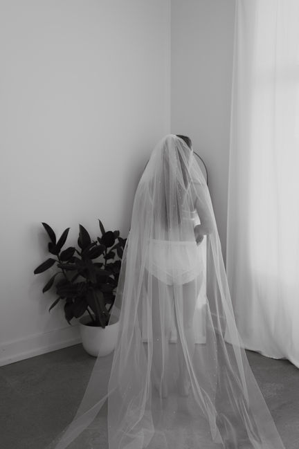 Bride in undergarments with veil.