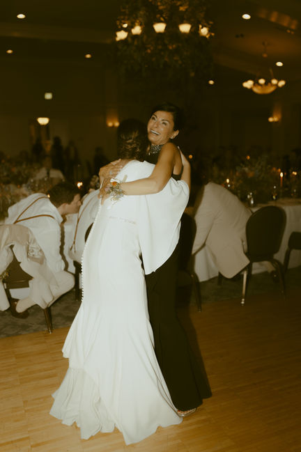Mother and bride dancing on dance floor.